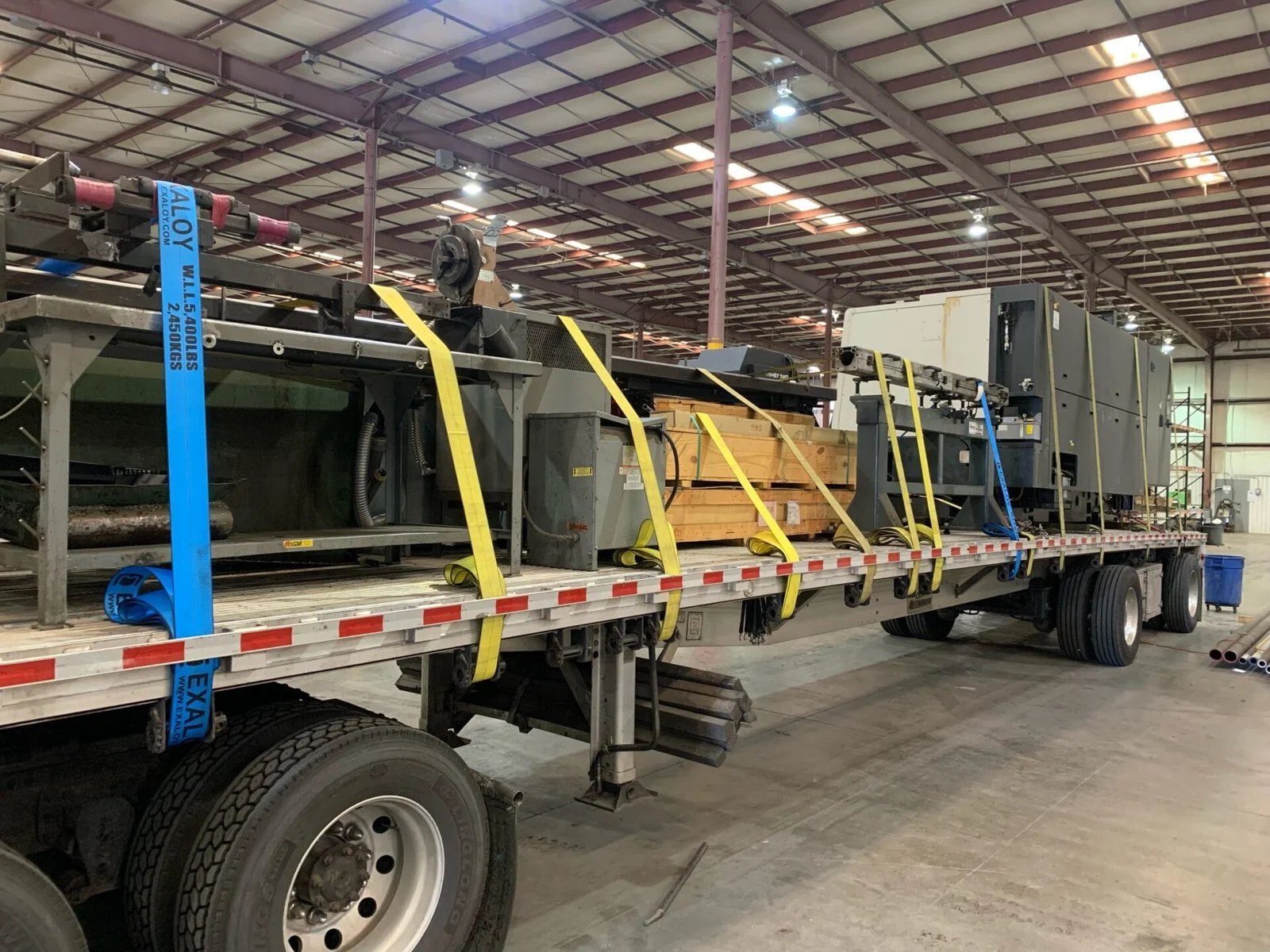 Heavy machinery secured flatbed turnkey industrial movers USA Mexico AZVIR
